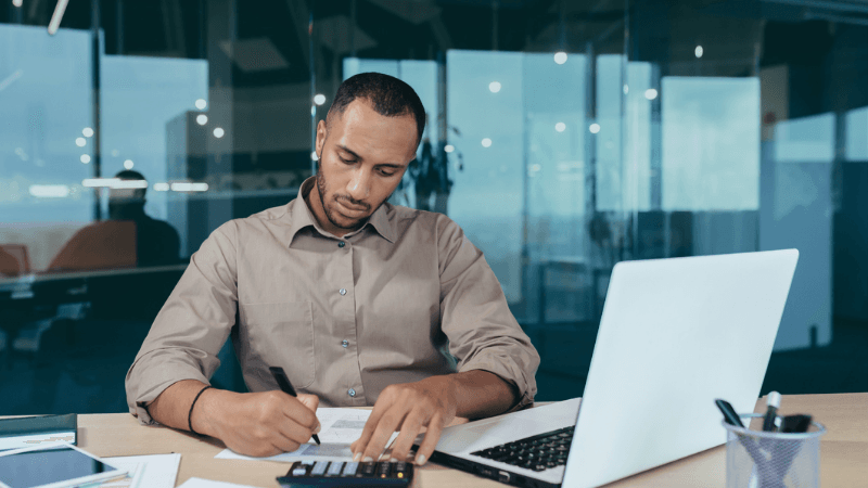 A Compliance Professional Reviewing Financial Data And Documentation At A Desk AI Compliance Hiring Why Fraud, Data, And Regulation Are Creating New Talent Needs